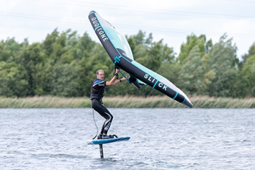 A man kite surfs on a lake