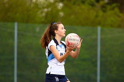 A girl plays netball outside