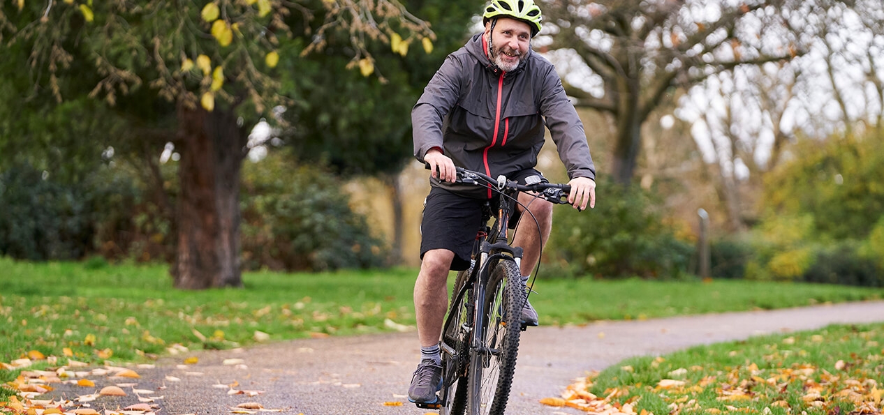 A man cycling through a park.