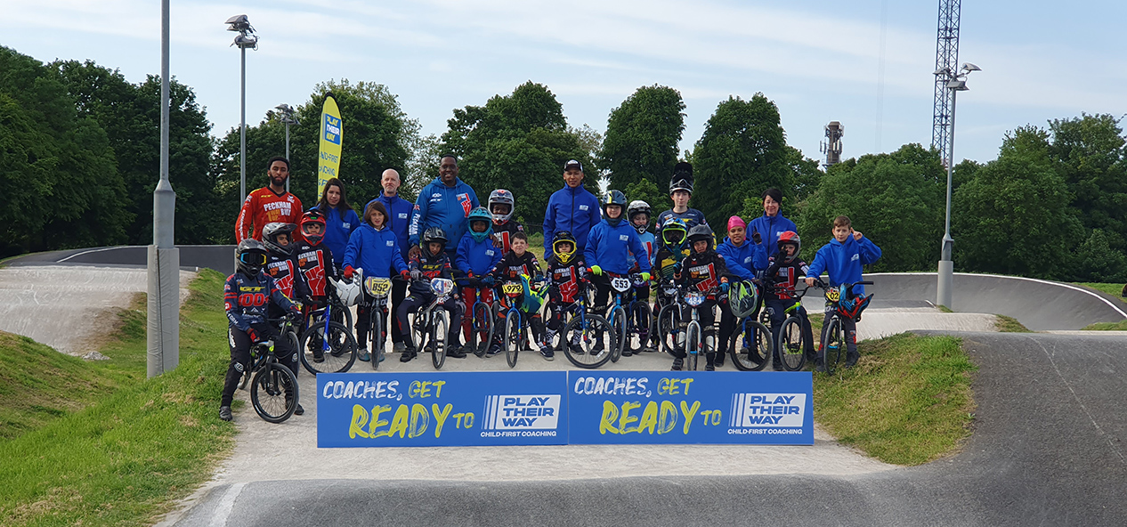 Children and coches from Peckham BMX Club pose for a picture on the track