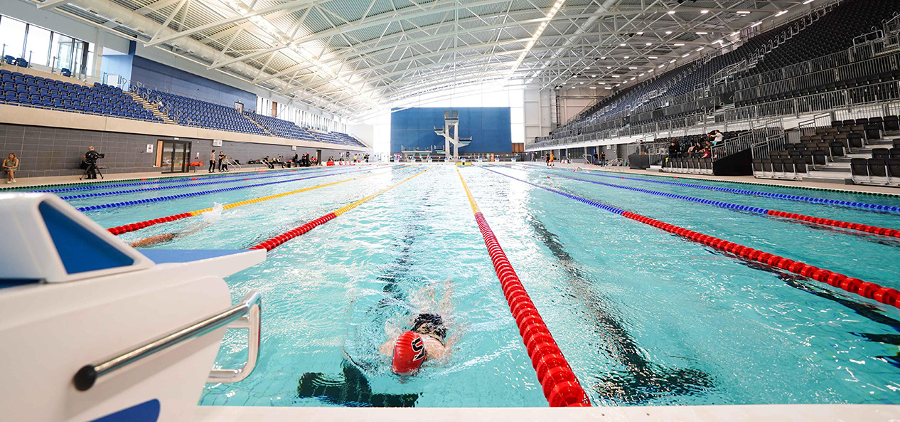 A single swimmer swims lengths in the 50m pool at the Sandwell Aquatics Centre