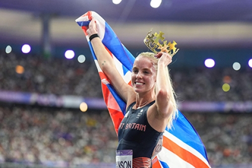 British Olympic champion Keely Hodgkinson celebrates her 800m victory at Paris 2024 with a Union flag and plastic crown