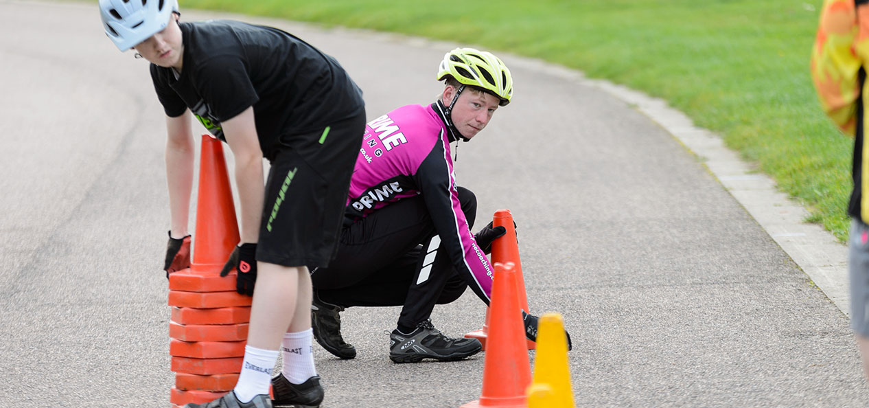 Two young cyclists lay out cones for a skills drill.