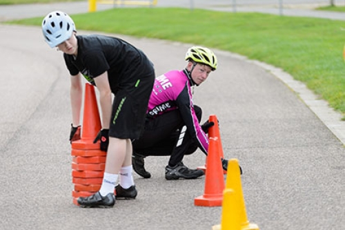 Two young cyclists lay out cones for a skills drill.