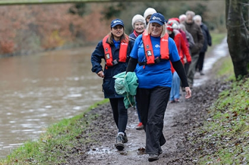 A group of adults walk along a towpath