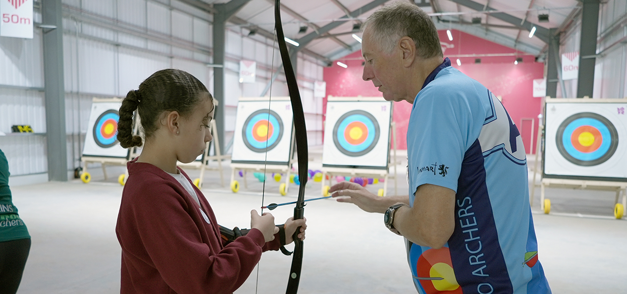 A girl is taught archery by an instructor at the Performance Archery Centre in Lilleshall.