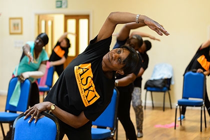 A group of women taking part in a chair exercise session.