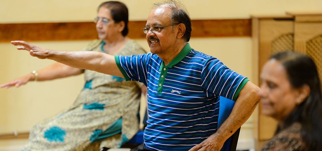 A group of people doing chair exercises.