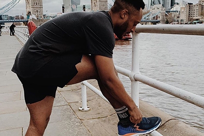 A man ties his shoe lace ahead of a run