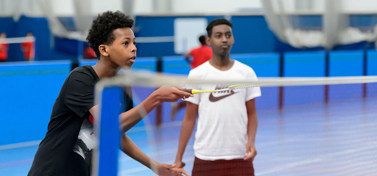 Two boys playing badminton