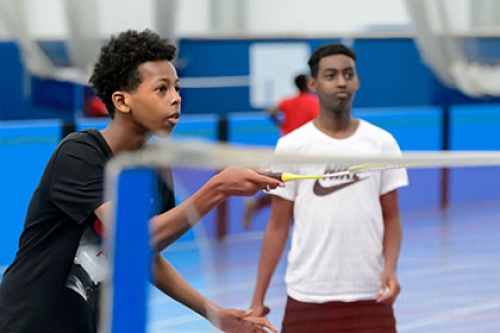 Two boys playing badminton