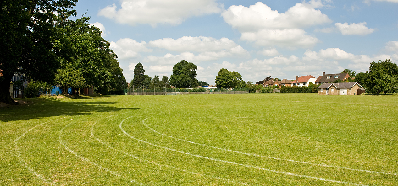 A playing field with a grass running track on it