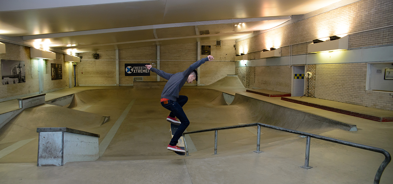 A boy skates in in a swimming pool that's been converted into a skate park