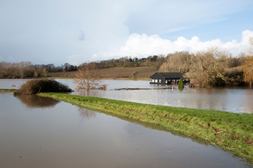 A flooded cricket pitch and pavilion after a river burst its banks.