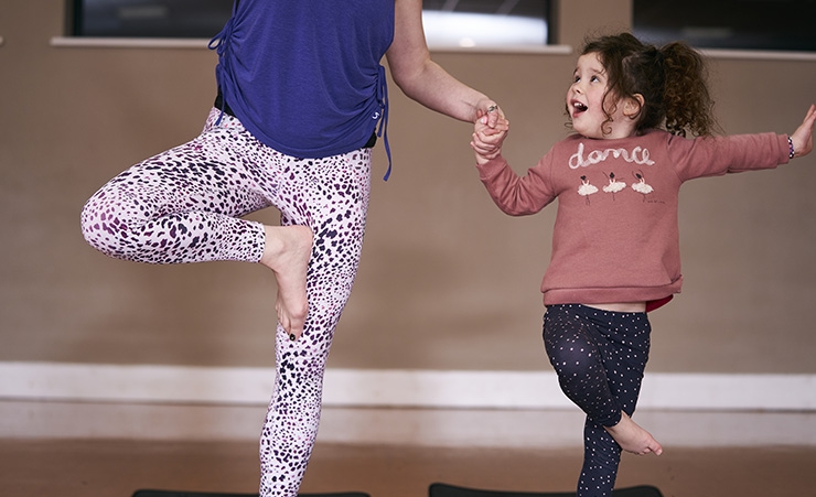 A woman and her daughter do yoga together