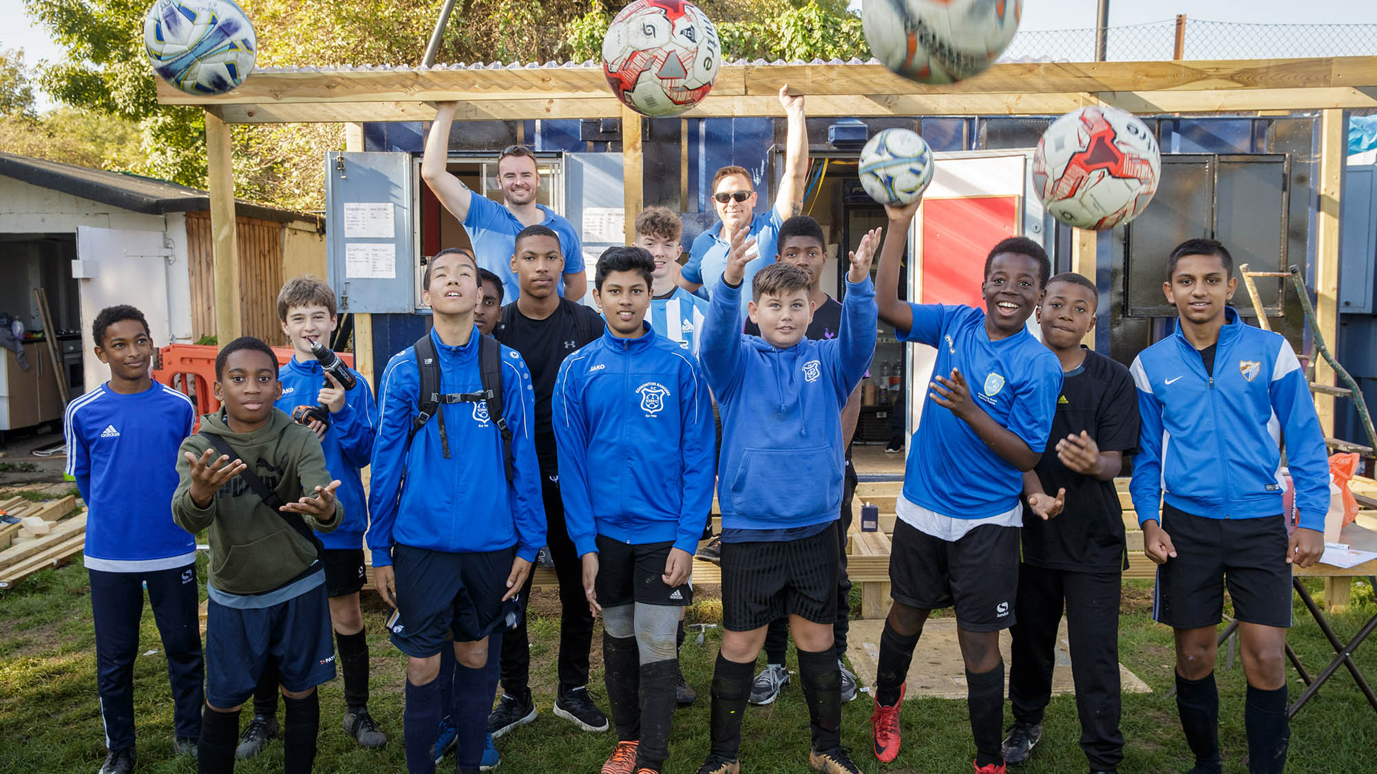 group of young boys throwing footballs