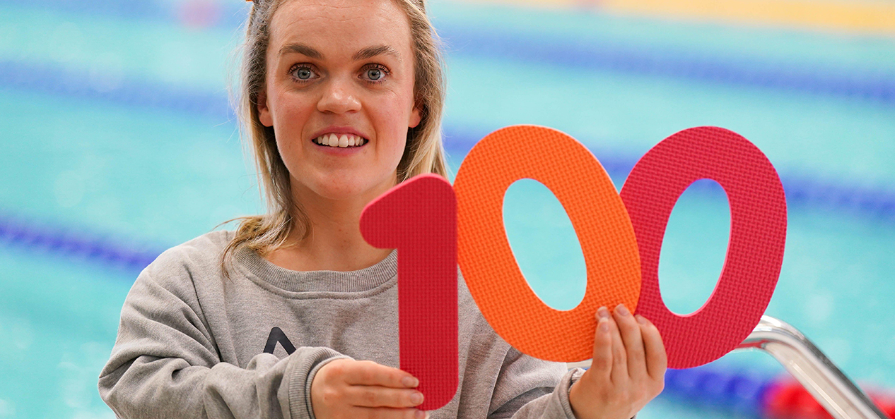 Para swimmer Ellie Simmonds holds up foam numbers spelling out 100 at Sandwell Aquatics Centre, marking 100 days to go until the start of the Birmingham 2022 Commonwealth Games