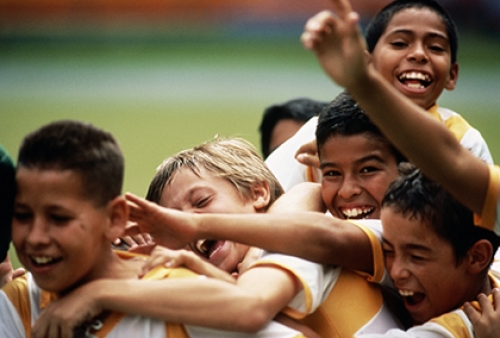 A group of young boys celebrate at a football match. Credit: Juan Silva/The Image Bank via Getty Images.