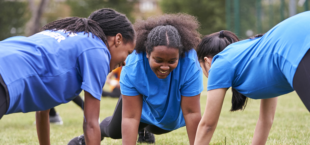 Three youngsters doing press ups and enjoying being active