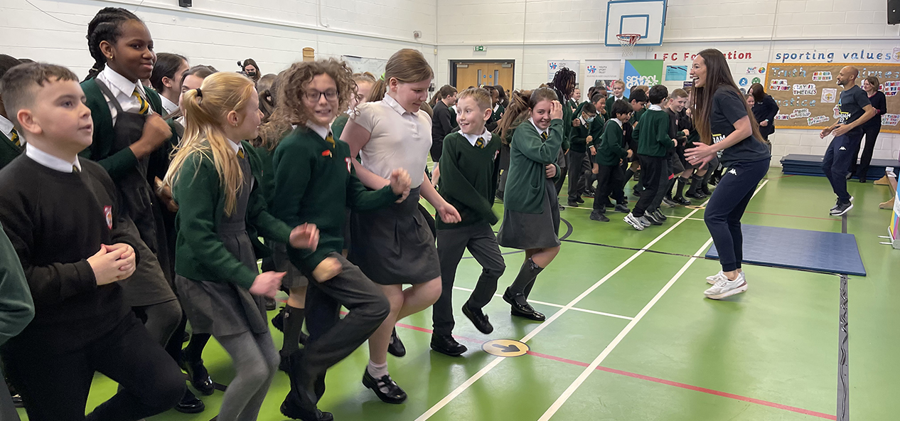 Primary school students take part in an 'Active Assembly' led by a Commonwealth Games athlete as part of a School Games initiative