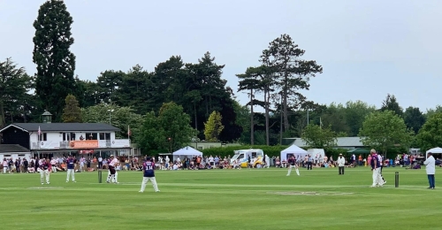 A wide shot of the Luton Town and Indians Cricket Pitch, with a game being played and crowd watching on