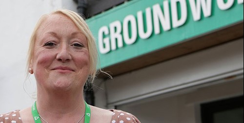 woman standing in front of groundwork shop