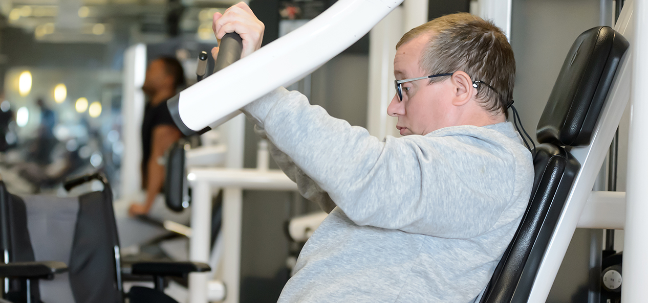 A man uses a chest press machine in the gym