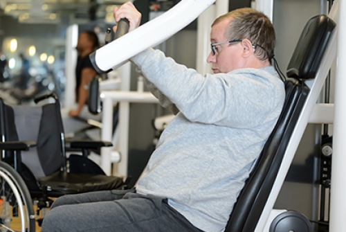 A man uses a chest press machine in the gym