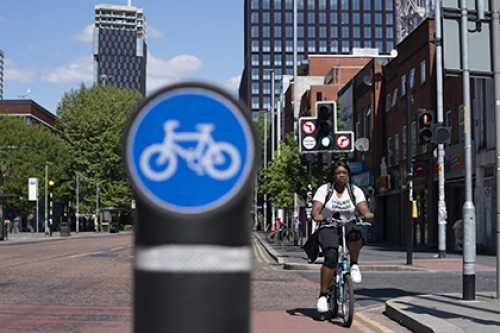 A woman cycles in a cycle lane in Manchester.