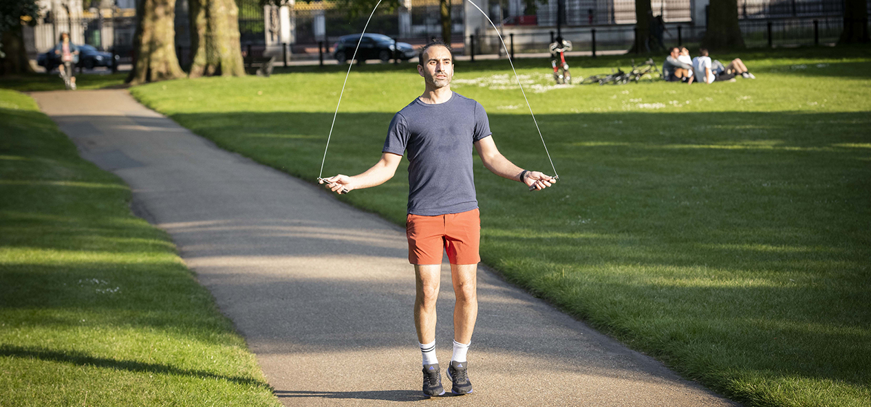 A man skipping on a path in a park