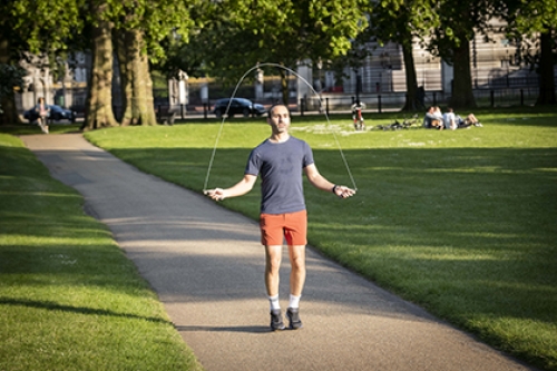 A man skipping on a path in a park