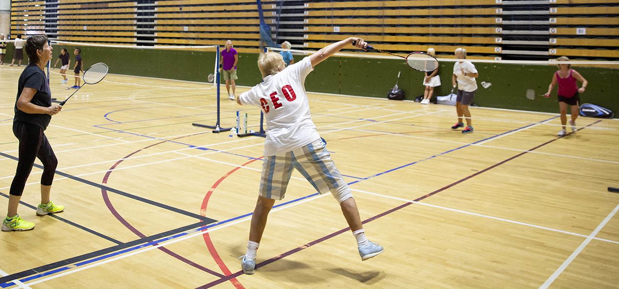 People play badminton in a sports hall