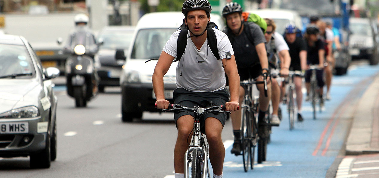 Cyclists ride on a cycle superhighway in London, alongside cars