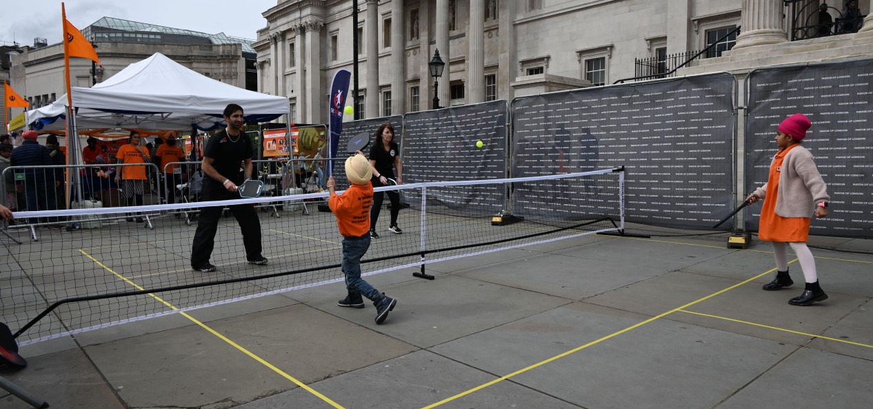 Adults and youngsters play pickleball at a pop-up Pickleball England stall during the Sikh Games in Trafalgar Square, London.