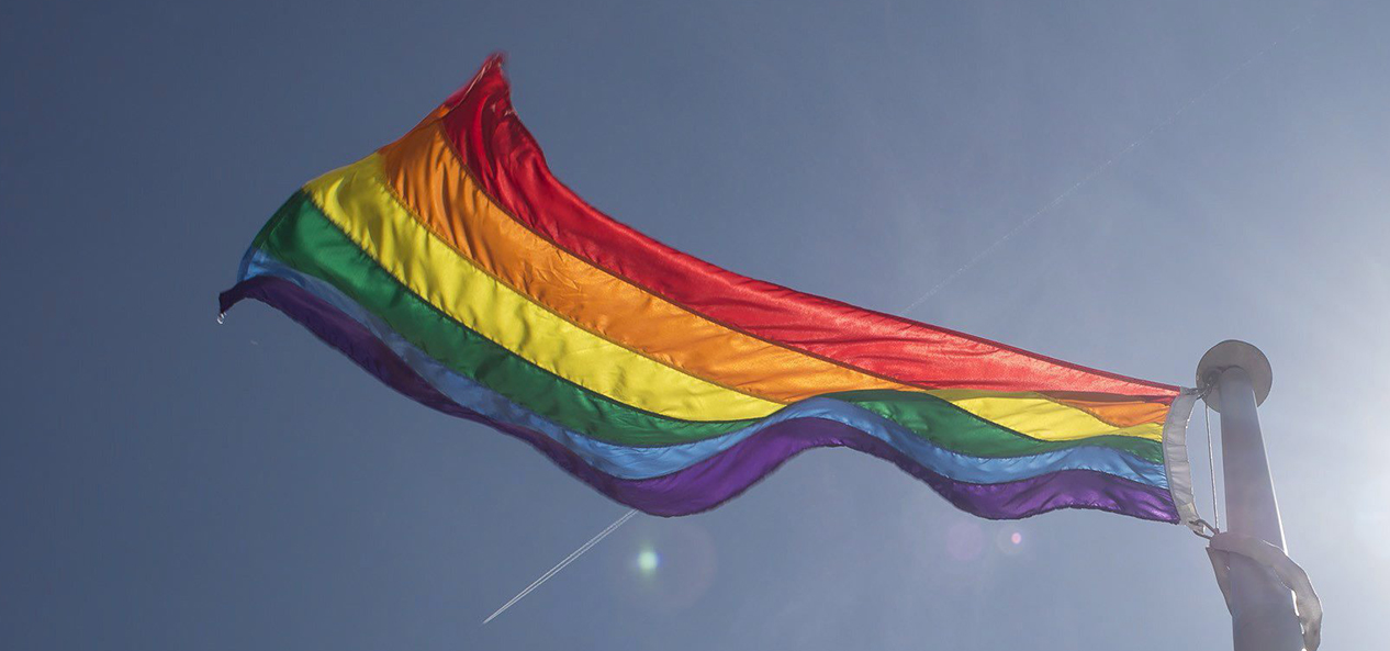 The Pride flag flutters in the sky