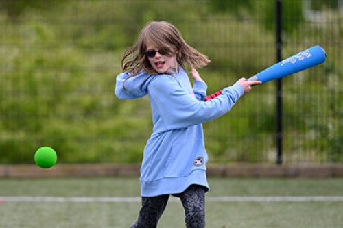 A girl playing rounders