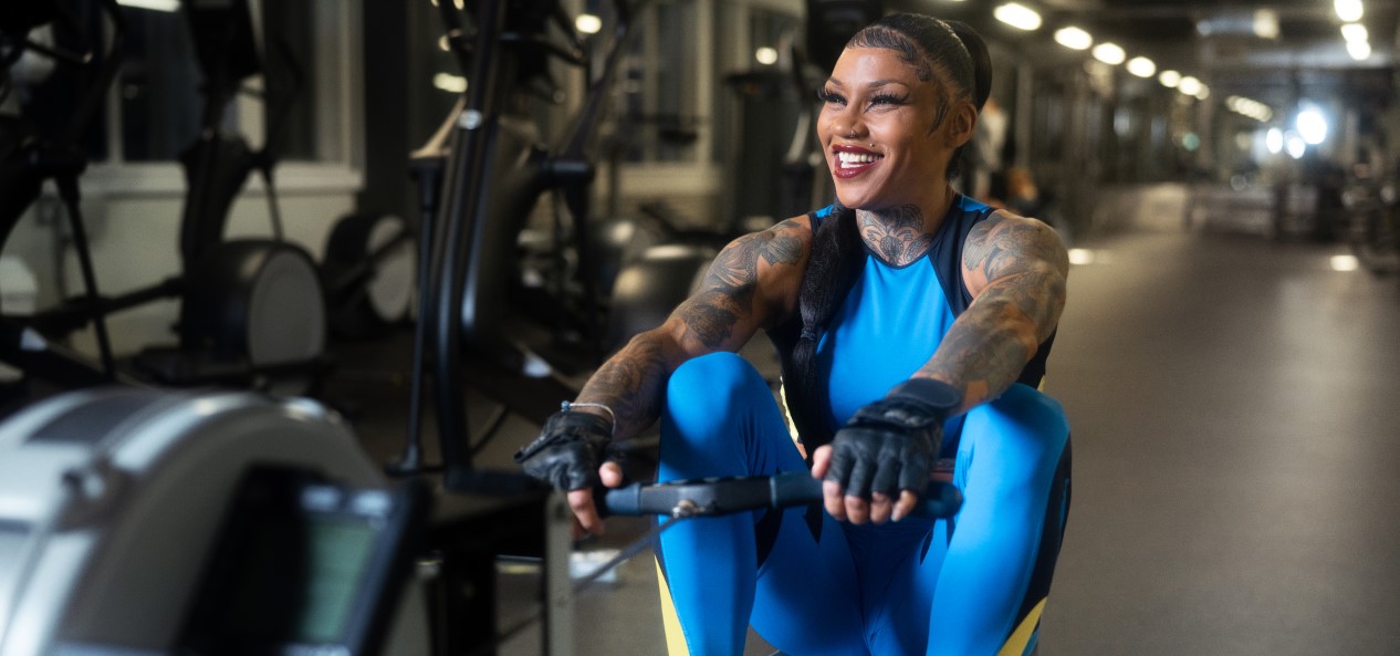 A smiling woman on a rowing machine in a gym