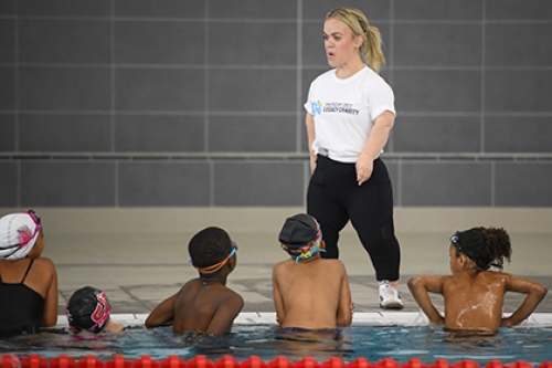 Ellie Simmonds stands at the side of the pool, coaching a group of children from the local community, at the opening of the Sandwell Aquatics Centre.