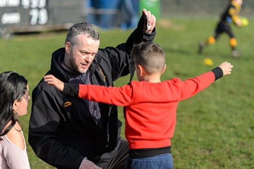 A coach puts tag rugby straps on a child