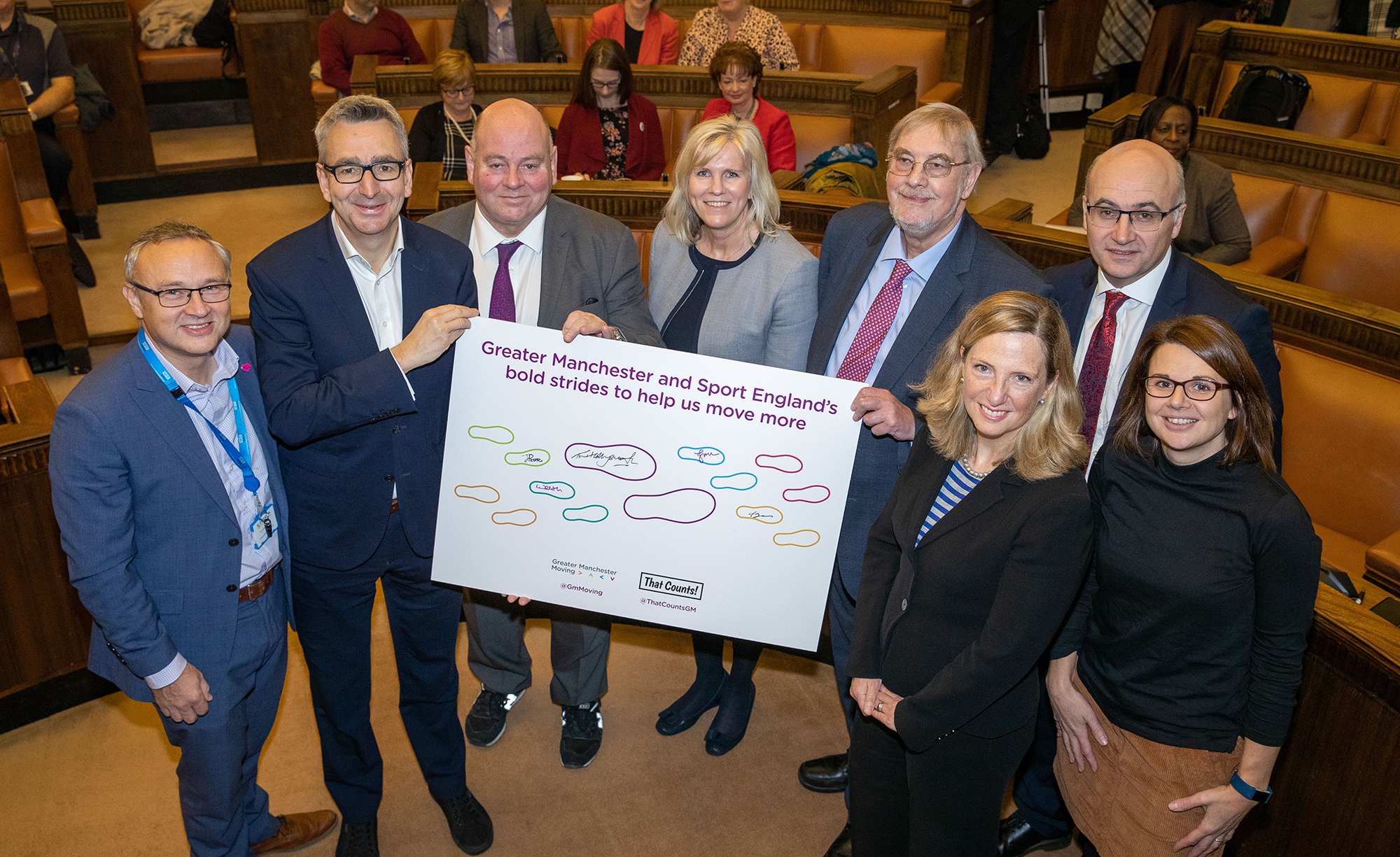 group of people holding a sign which reads Greater Manchester and sport England's bold strides to help us move more