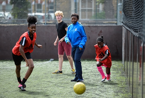 A coach watches on during a football session on a five-a-side pitch