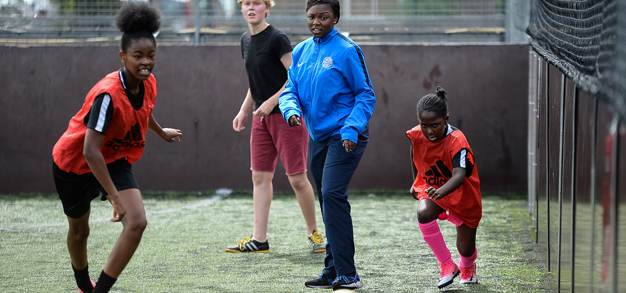 A coach watches on during a football session on a five-a-side pitch