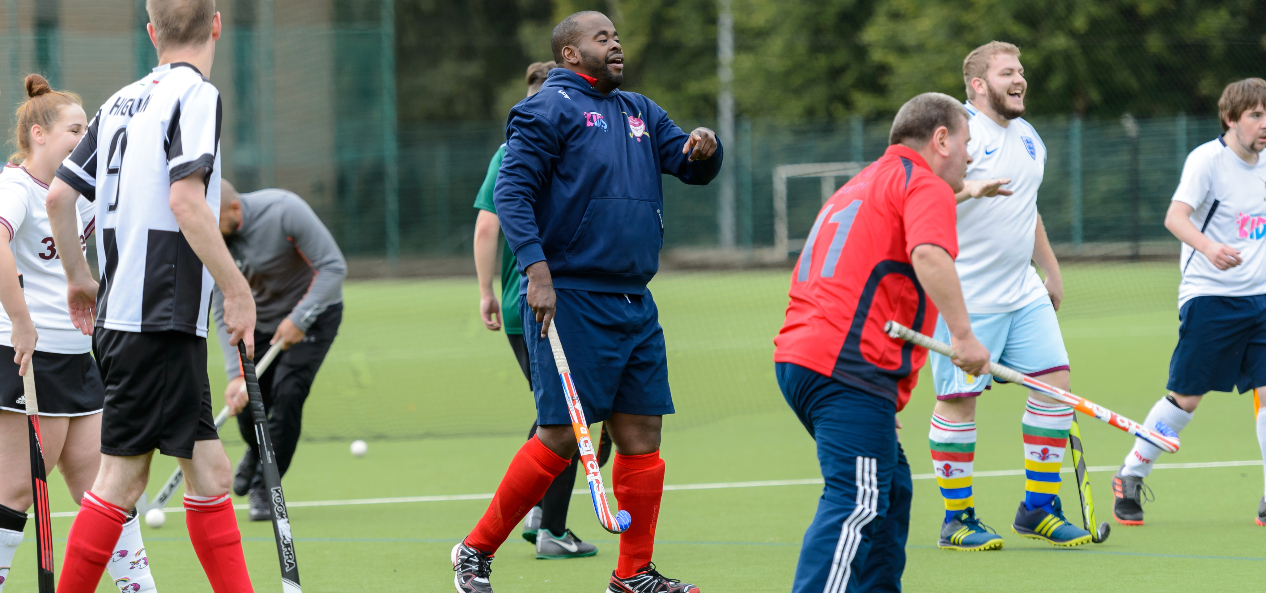 Teams playing hockey on outdoor pitch