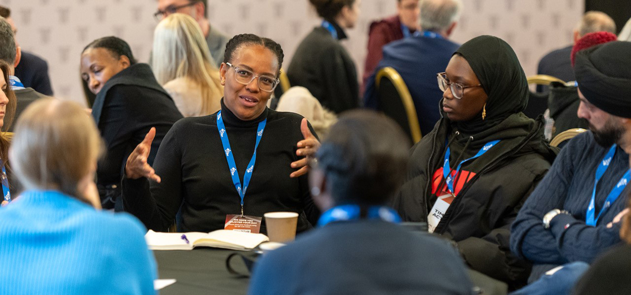 Delegates at a tackling racism conference talk around a table