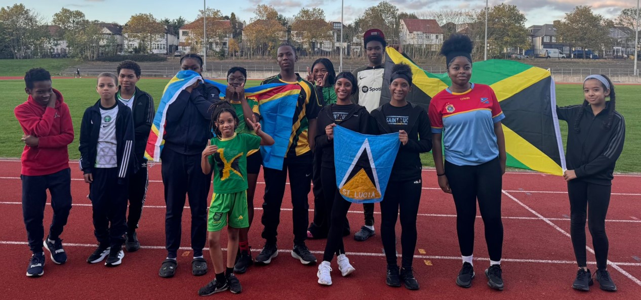 Young people posing with flags on an athletics track