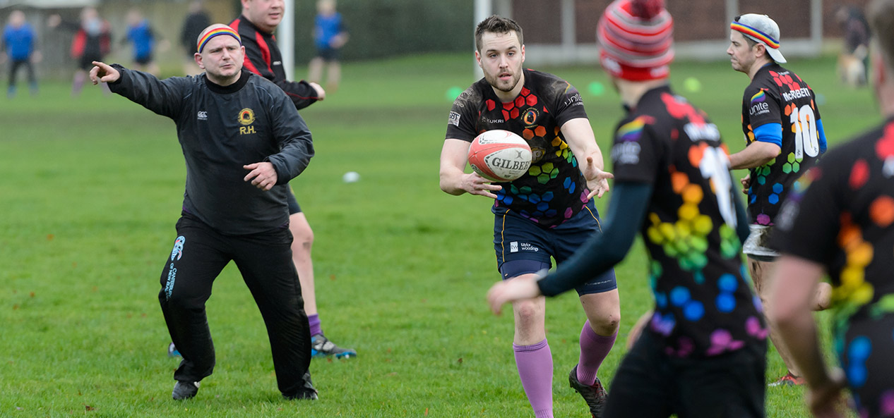 A man passes a rugby ball to a teammate during a training session