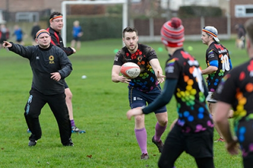 A man passes a rugby ball to a teammate during a training session