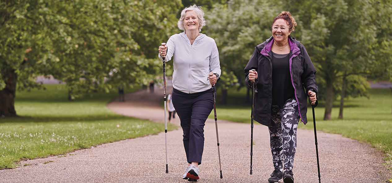 Two women enjoy a walk on a nice, wide path