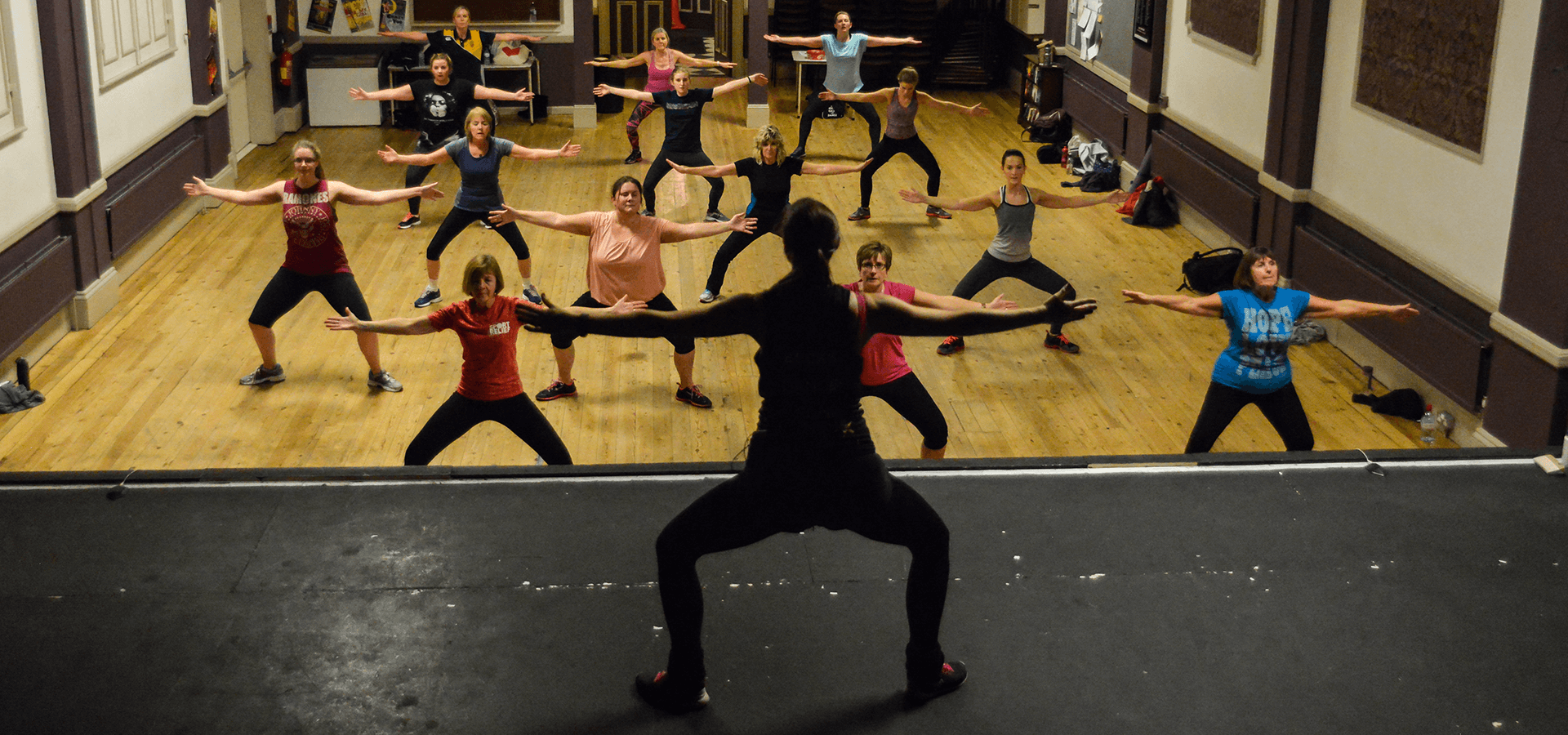 instructor teaching stretches in an exercise class for women