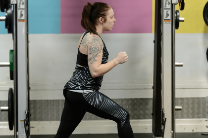 Girl working out in gym in front of weights rack